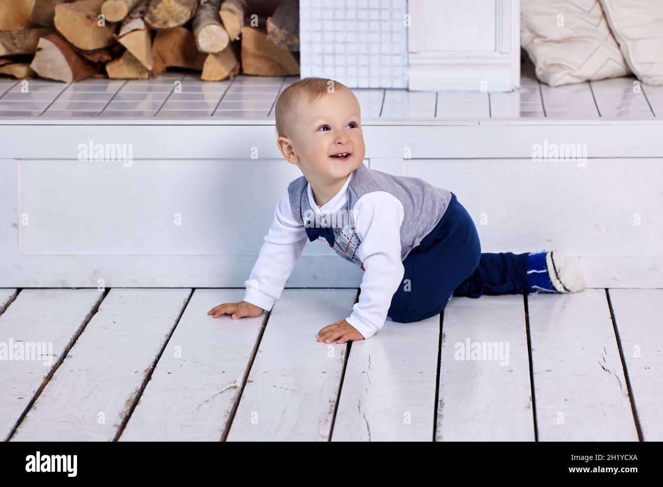 In der Lounge kriecht ein Kleinkind auf dem Boden und lächelt. Stockfoto