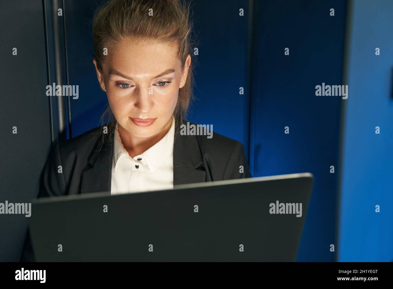 Eine Technikerin, die einen Laptop zur Analyse des Servers verwendet Stockfoto