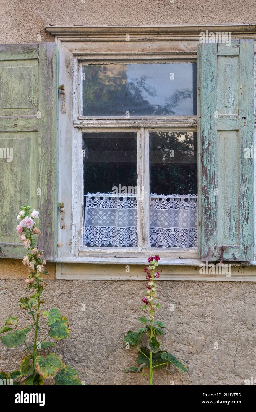 Ein altes Fenster mit offenen Fensterläden, Zeugen der Vergangenheit Stockfoto