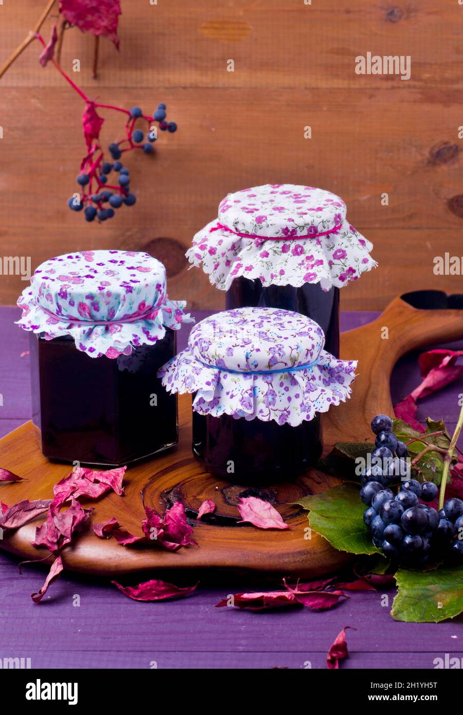 Gläser mit Traubengelee mit herbstlichen Blättern Stockfoto