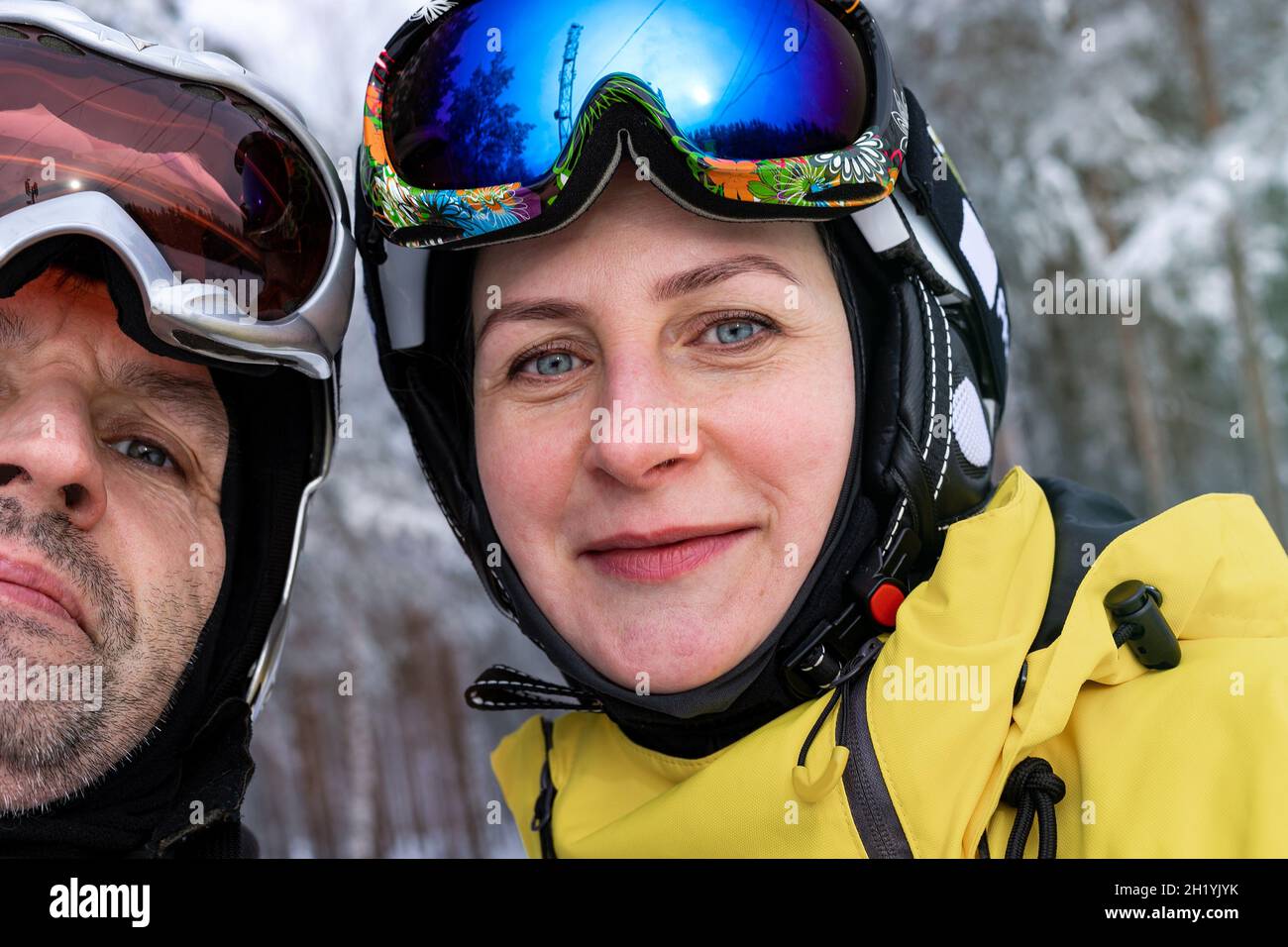 Ein glücklicher Mann und eine Frau kaukasischer Herkunft in Skihelmen und Skibrillen machen ein Selfie. Aktiver Lebensstil und extremer Wintersport. Winter Stockfoto