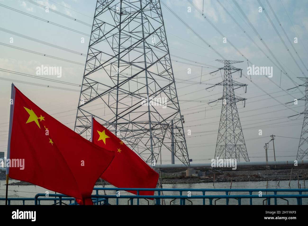 Die chinesische Flagge winkt vor den Hochspannungstürmen in Tianjin, China. 19-Okt-2021 Stockfoto