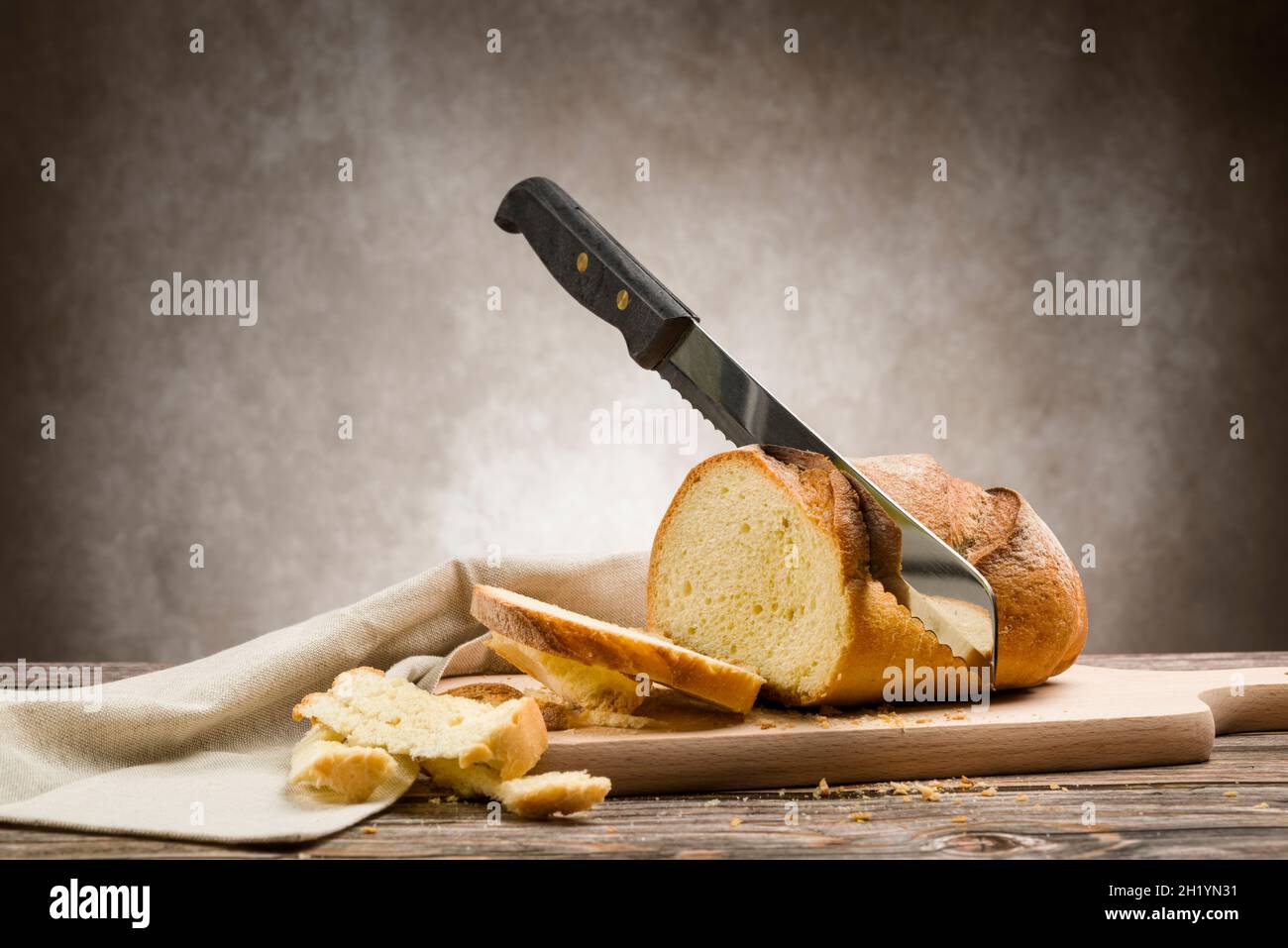 Vollkornbrot auf Küchentisch mit Messer zum Schneiden Stockfoto