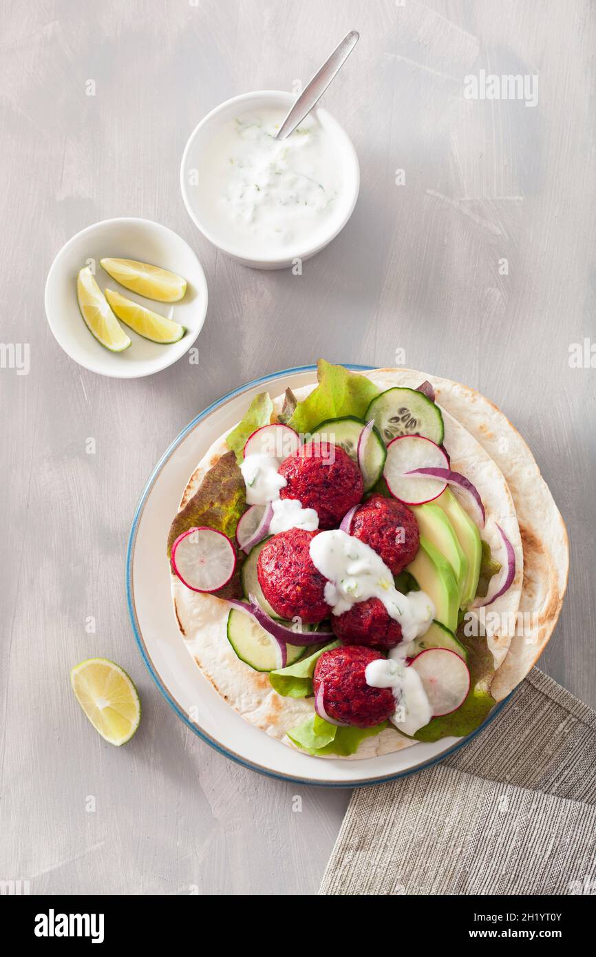 Tortilla mit Rübenfalafel, Avocado, Rettich, Gurke und Joghurtdressing Stockfoto