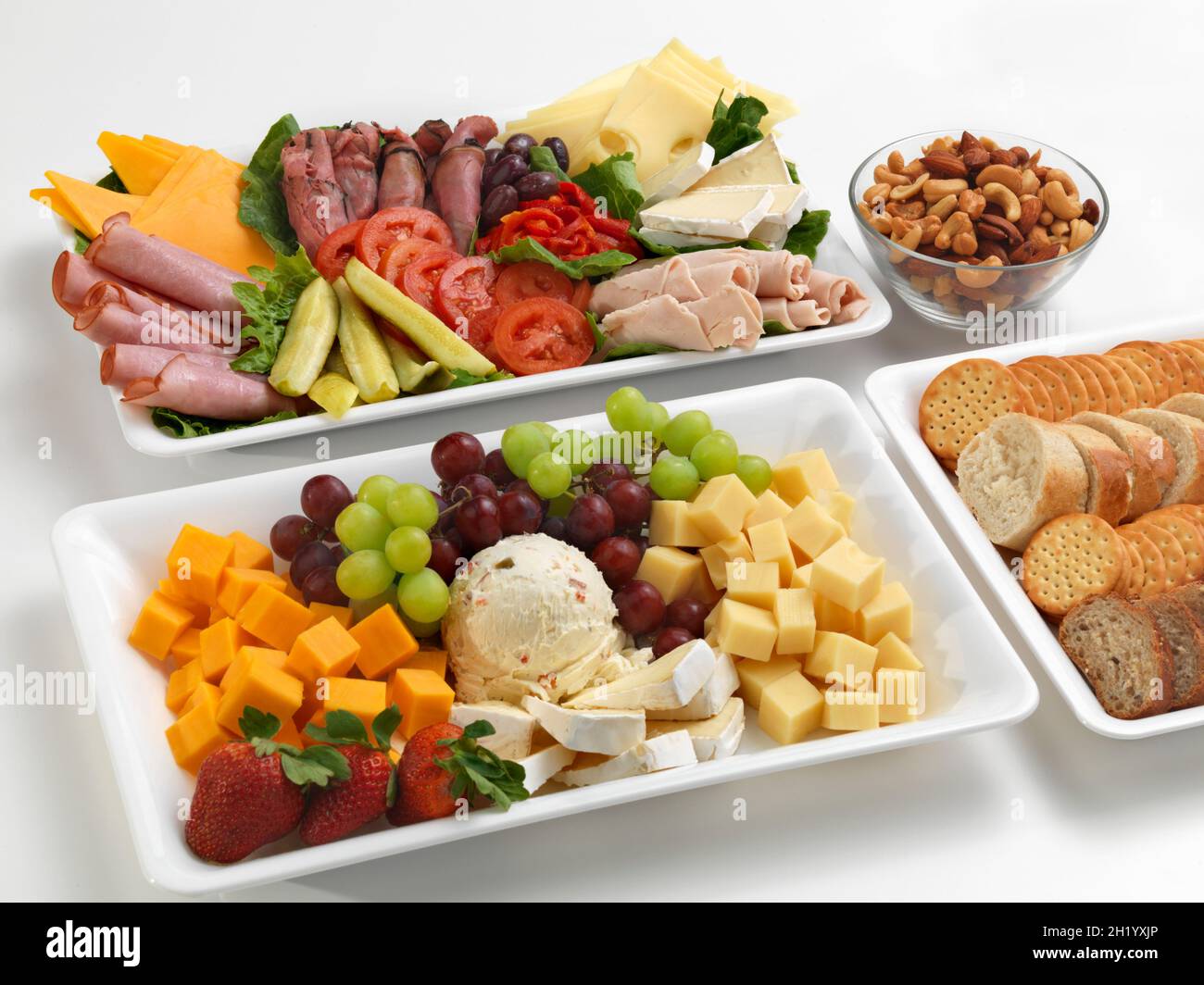 Verschiedene herzhafte und süße Snacks auf Platten Stockfoto