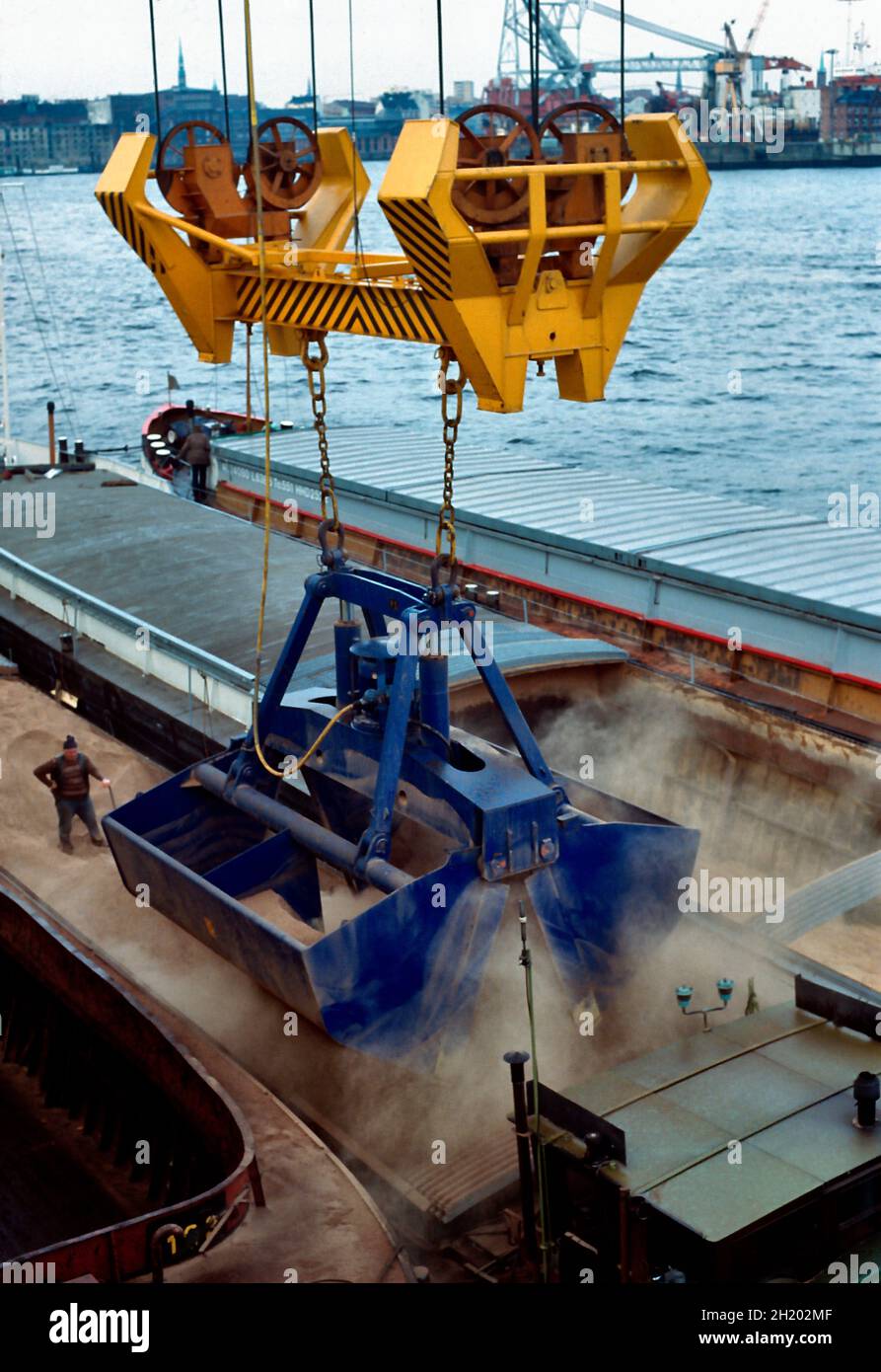 Füttern Sie Getreide, das im Hamburger Hafen mit einem Greifkran Schiff zu Schiff verladen wird. Stockfoto