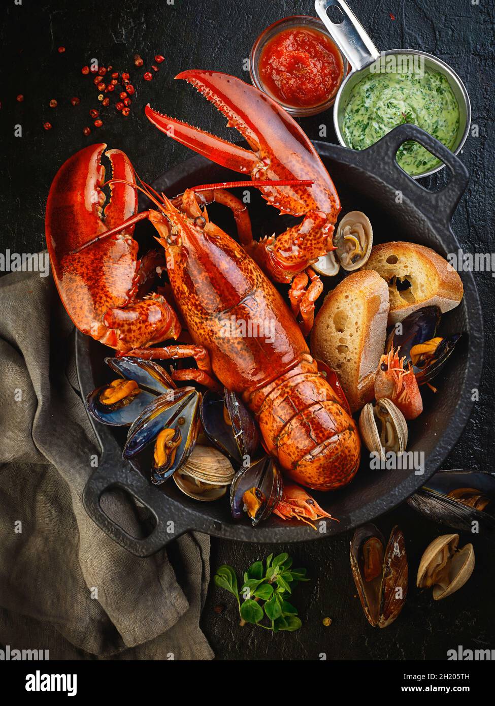 Gekochter Hummer, Muscheln und Garnelen mit Brot in einem Topf Stockfoto