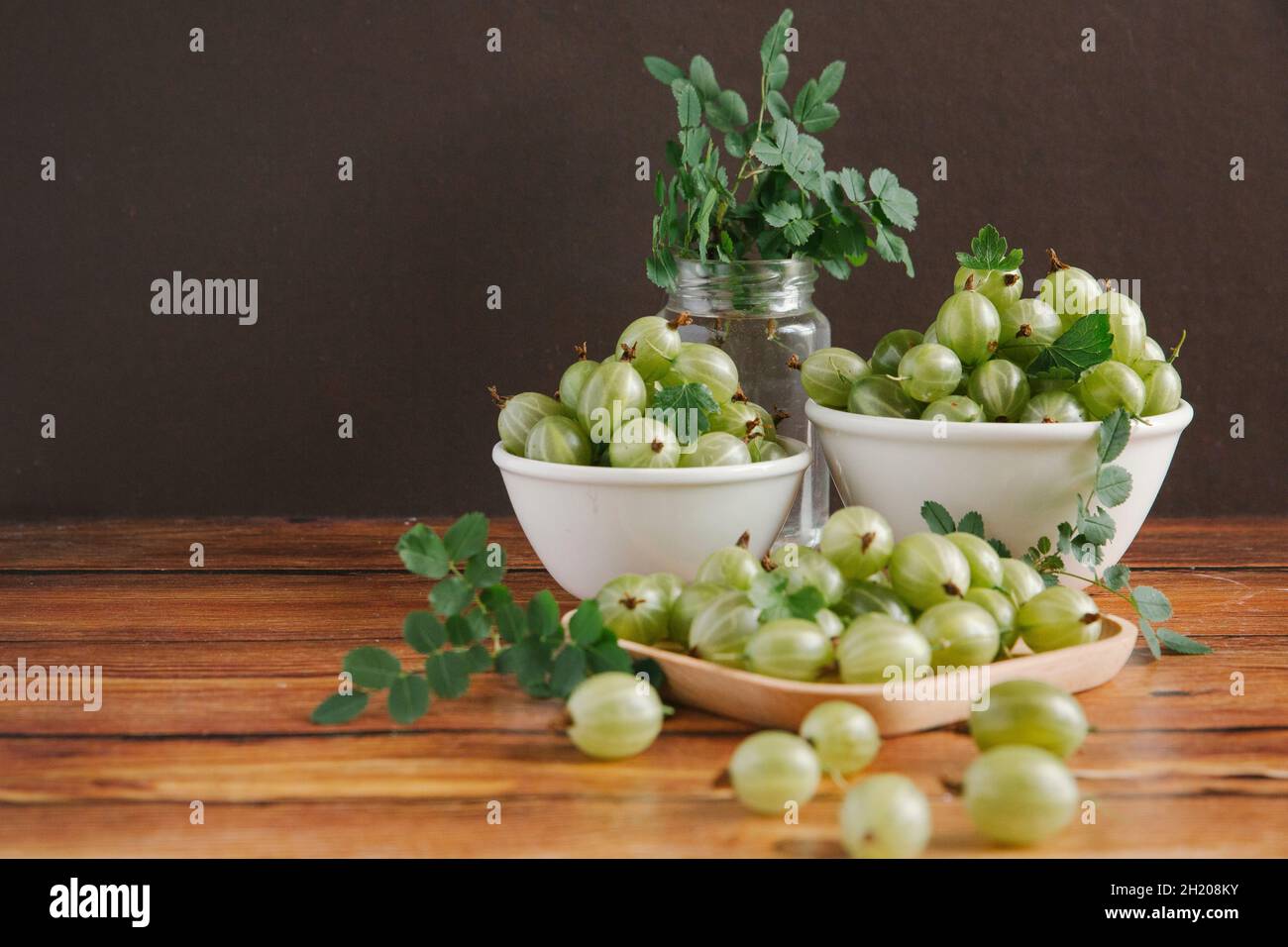 Stachelbeeren in kleinen Schüsseln auf einem Holztisch Stockfoto