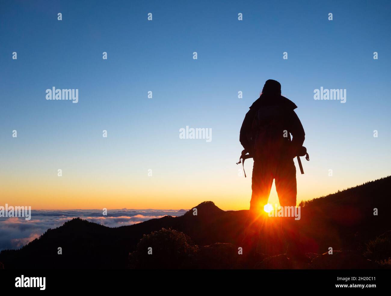 Frau, Frau Wanderer, Wandern, Wandern in den Bergen über Wolke Umwandlung bei Sonnenaufgang. Stockfoto