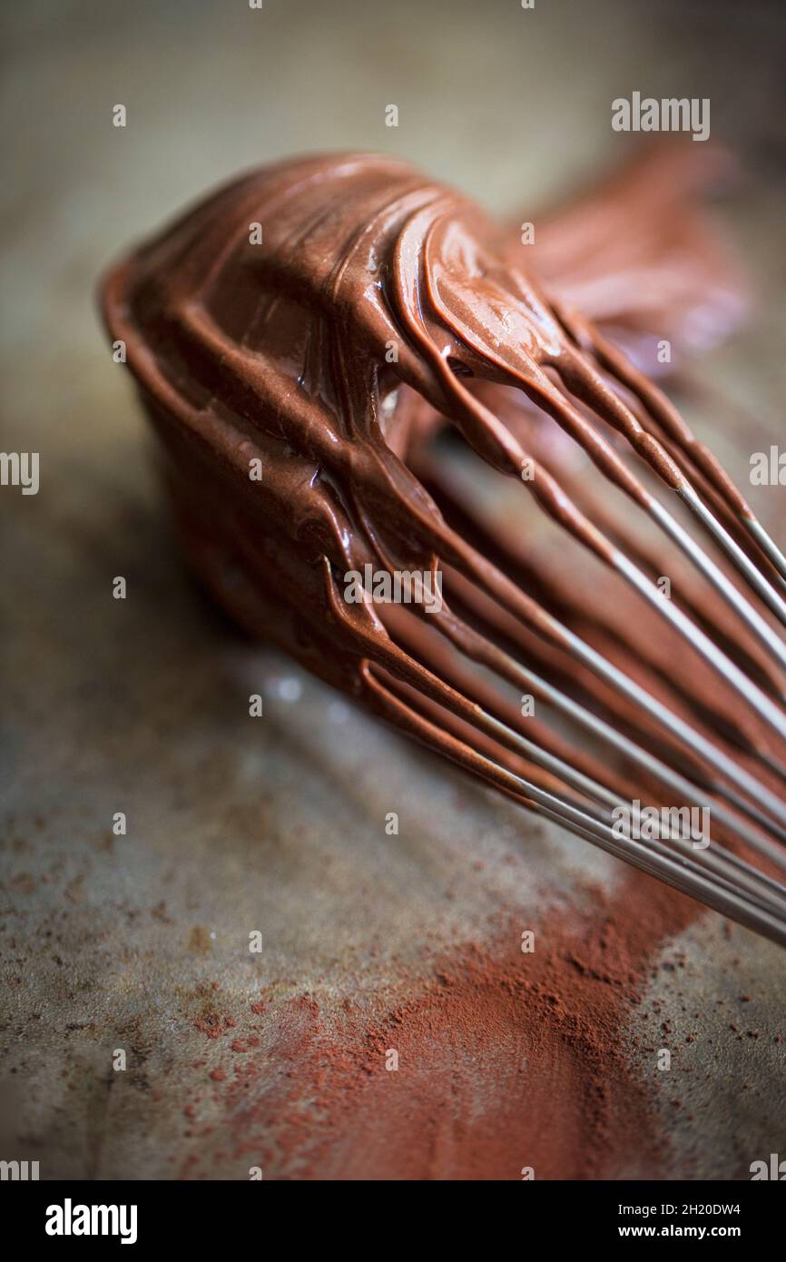 Ein Schneebesen, der mit Schokoladencreme überzogen ist Stockfoto