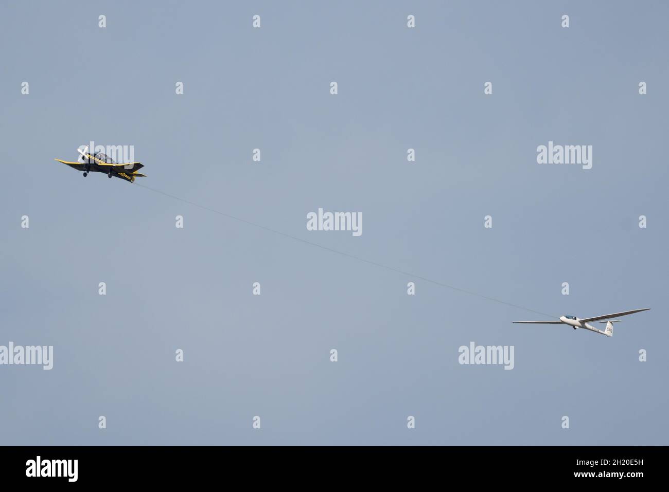 Ein Robin DR400 Schlepper (G-BJUD) schlepp einen Schempp-Hirth Discus Glider (G-CFXM) aus dem Lasham Gliding Center in Hampshire, Großbritannien Stockfoto