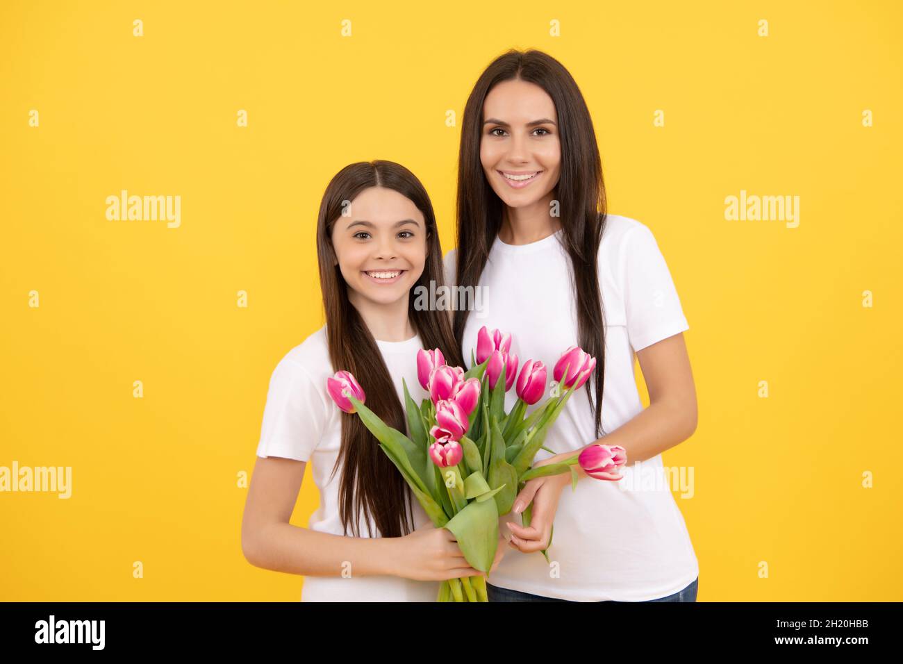 Glückliche Tochter Kind Mädchen und Mutter mit Blumenstrauß Frühling Tulpe Blumen für 8 märz Urlaub, Frauentag Stockfoto