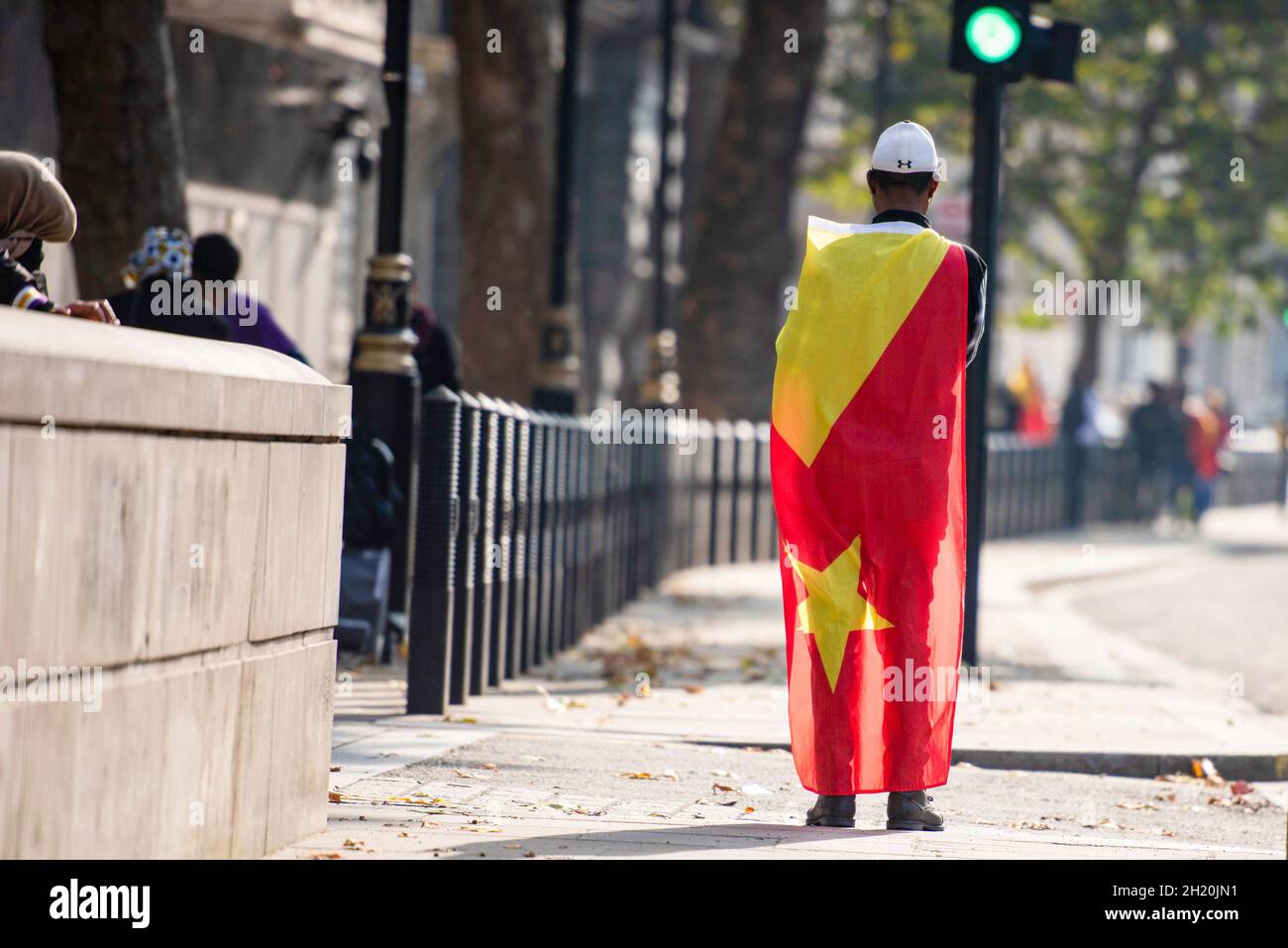 London, Großbritannien. Oktober 2021. Während des Tigray-Genozids in der Nähe der Downing Street 10 in London wird ein Protestler in die Flagge von Tigray gehüllt gesehen. Die Demonstranten protestierten gegen einen sogenannten „Völkermord-Krieg“ von Äthiopien und Eritrea in der Region Tigray und forderten das Vereinigte Königreich und die internationale Gemeinschaft auf, den Menschen in Tigray zu helfen. Kredit: SOPA Images Limited/Alamy Live Nachrichten Stockfoto