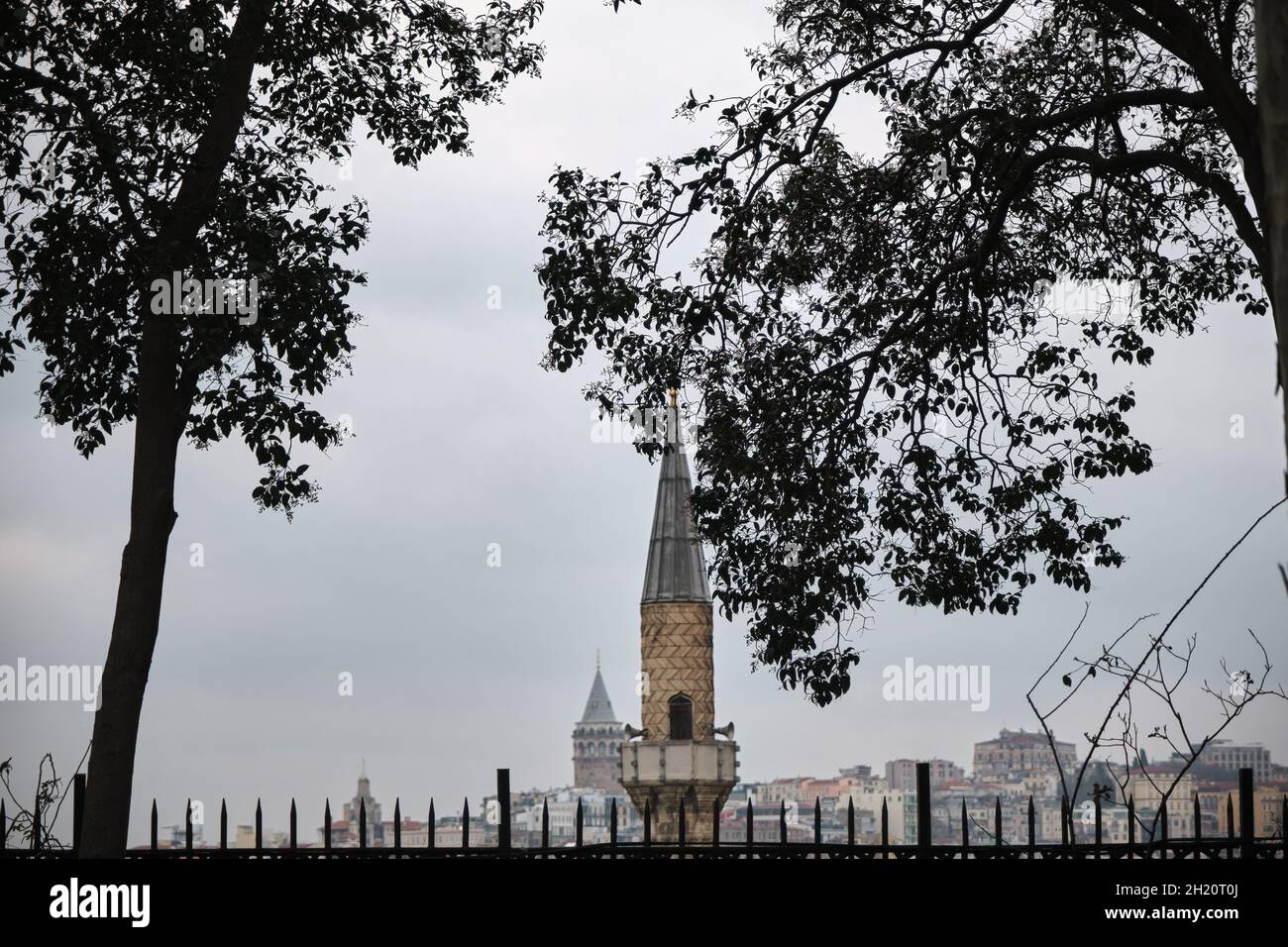Minarett einer Moschee Blick vom Gulhane Park istanbul mit Antiker Galata Tower Hintergrund während des bewölkten und regnerischen Tages in istanbul im März Stockfoto