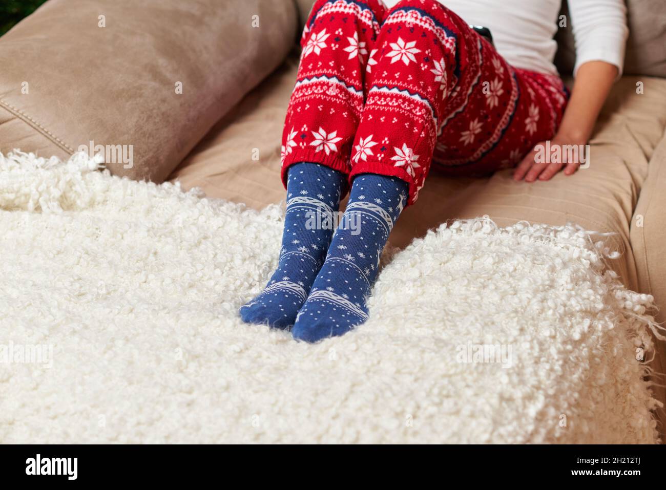 Person mit Weihnachtssocken und Schlafanzug Stockfoto