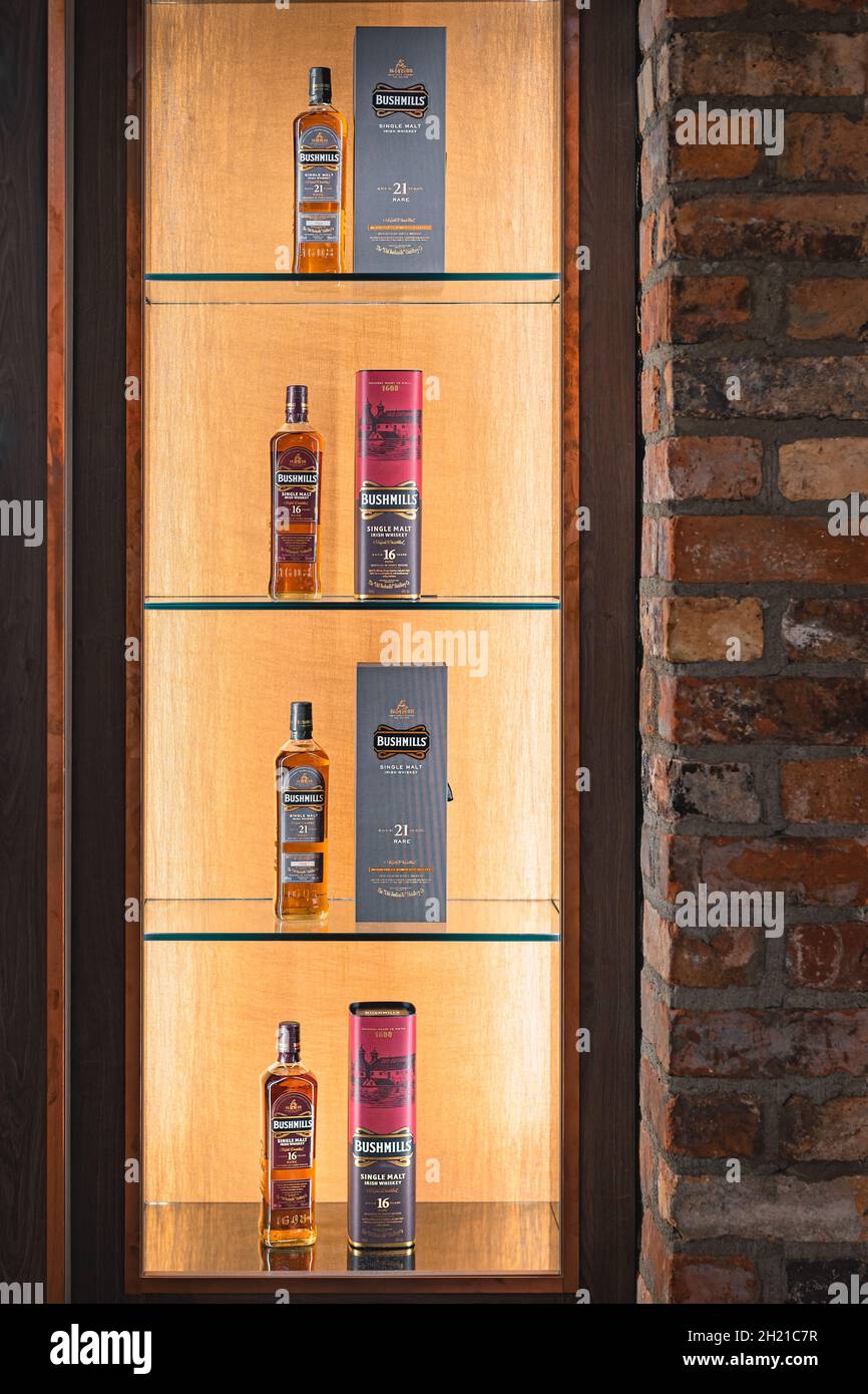 Bushmills, Nordirland, Aug 2019 Auswahl an 16 und 21 Jahre gealterten Bushmills Whiskey mit einer Box auf beleuchtetem Display im Brennerladen Stockfoto