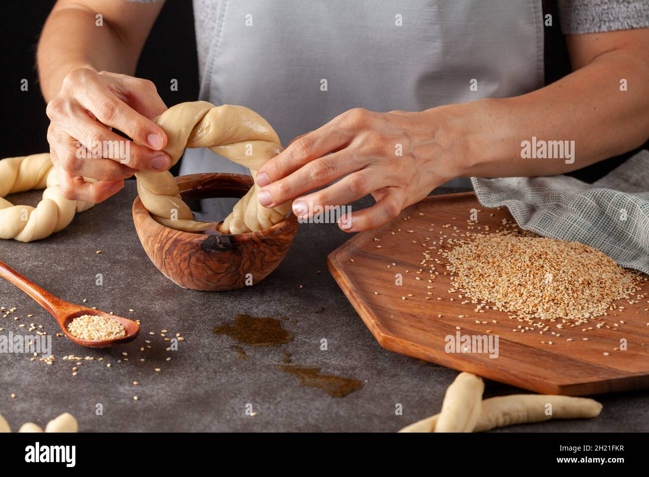 Köstlicher türkischer Bagel mit Sesamsamen, bekannt als Susamli simit. Eine Küchenchefin taucht die Brötchen in Traubenmelasse, um Sesamsamen zu kleben Stockfoto