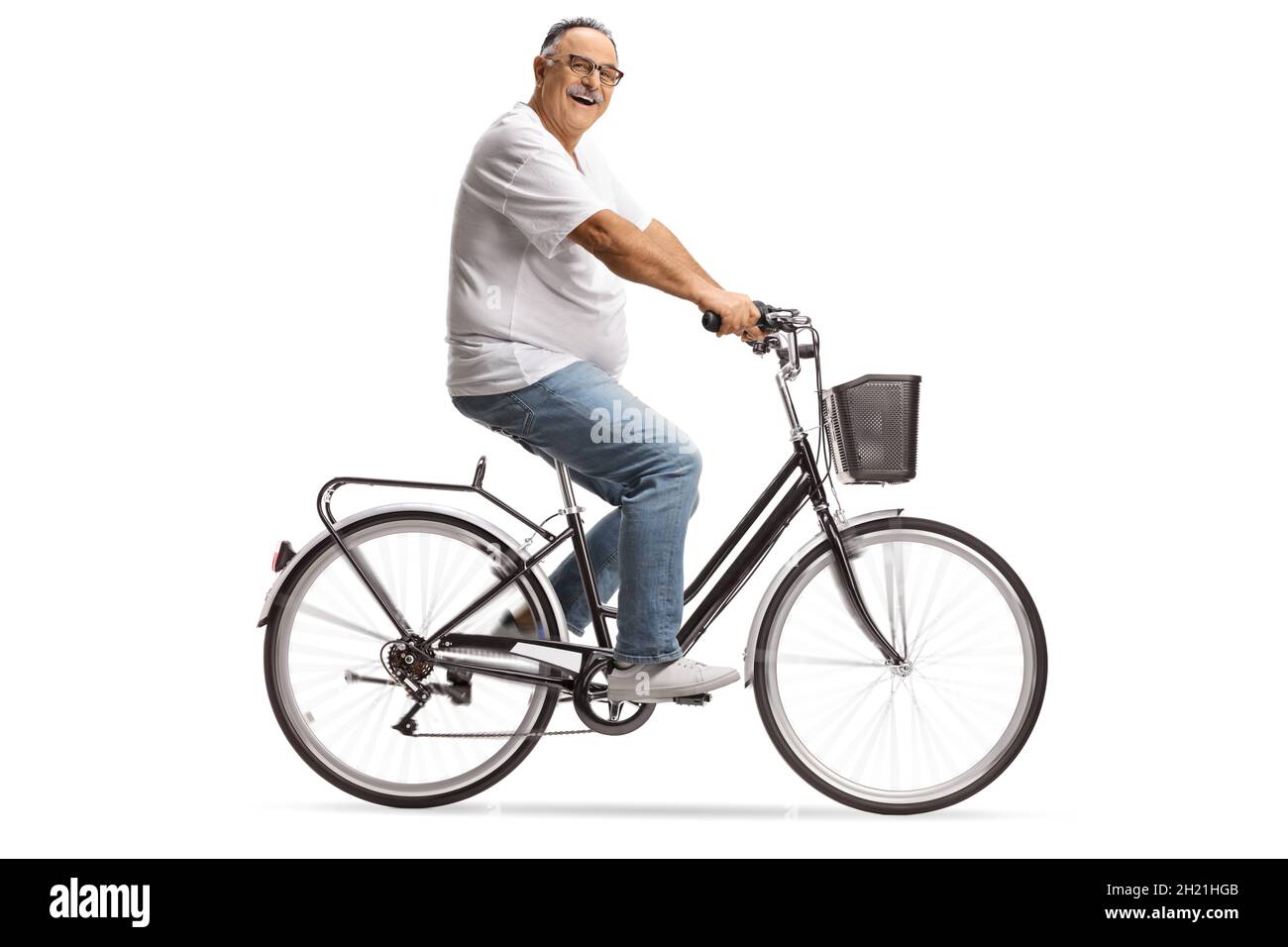 Lächelnder reifer Mann in Jeans und weißem T-Shirt auf einem Fahrrad isoliert auf weißem Hintergrund Stockfoto