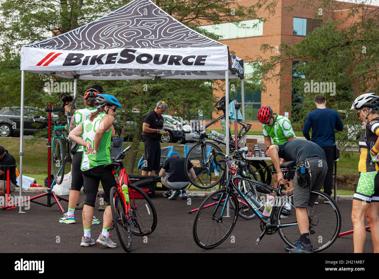 Columbus, OH USA 08-07-2021: Pelotonia Cancer Research Center Charity Ride-Veranstaltung, bei der Radfahrer auf einem Parkplatz anhalten, um Fahrräder zu reparieren und zu entspannen Stockfoto