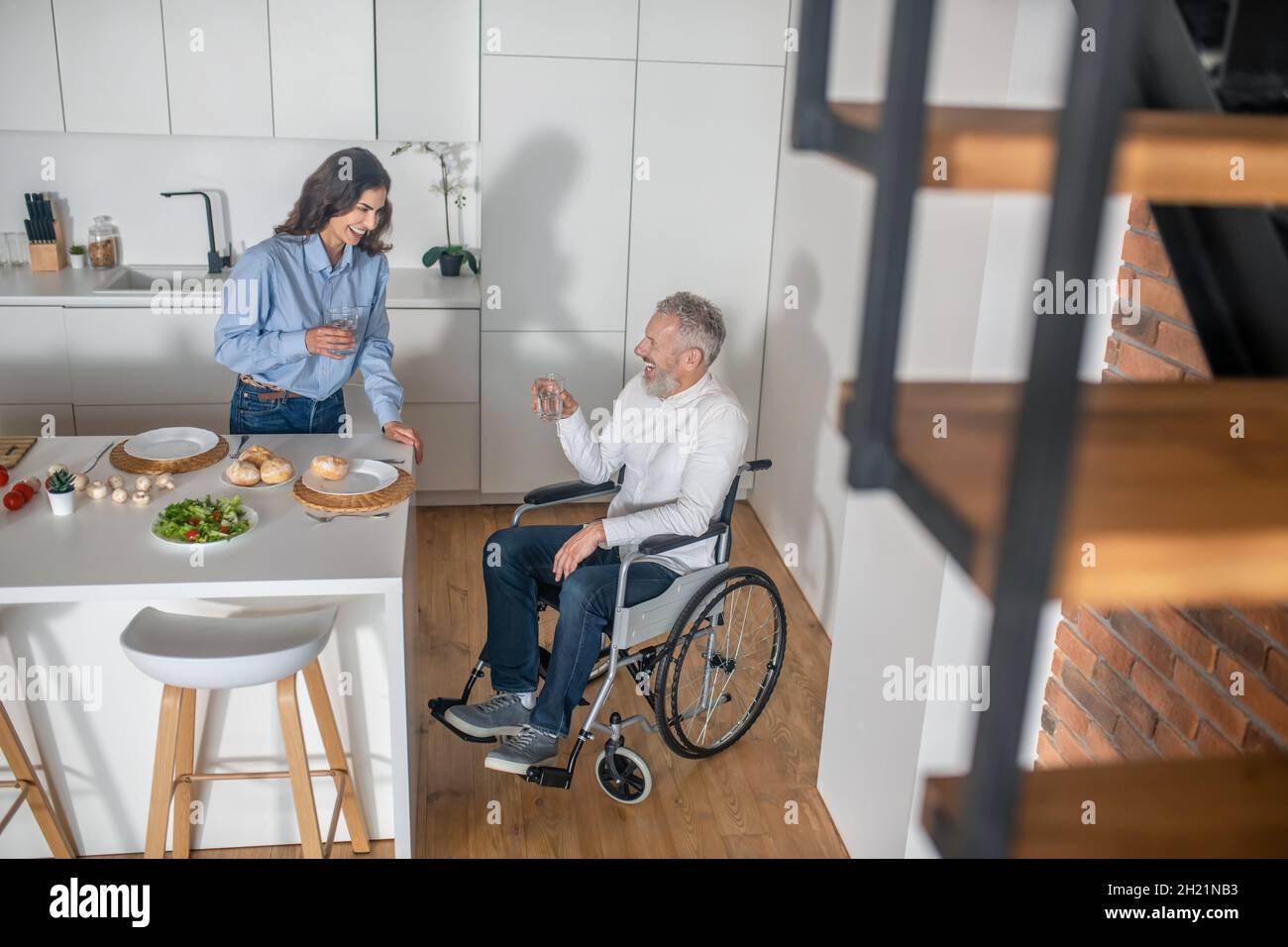 Ein Mann auf einem Rollstuhl und seine Frau verbringen den Morgen zusammen Stockfoto