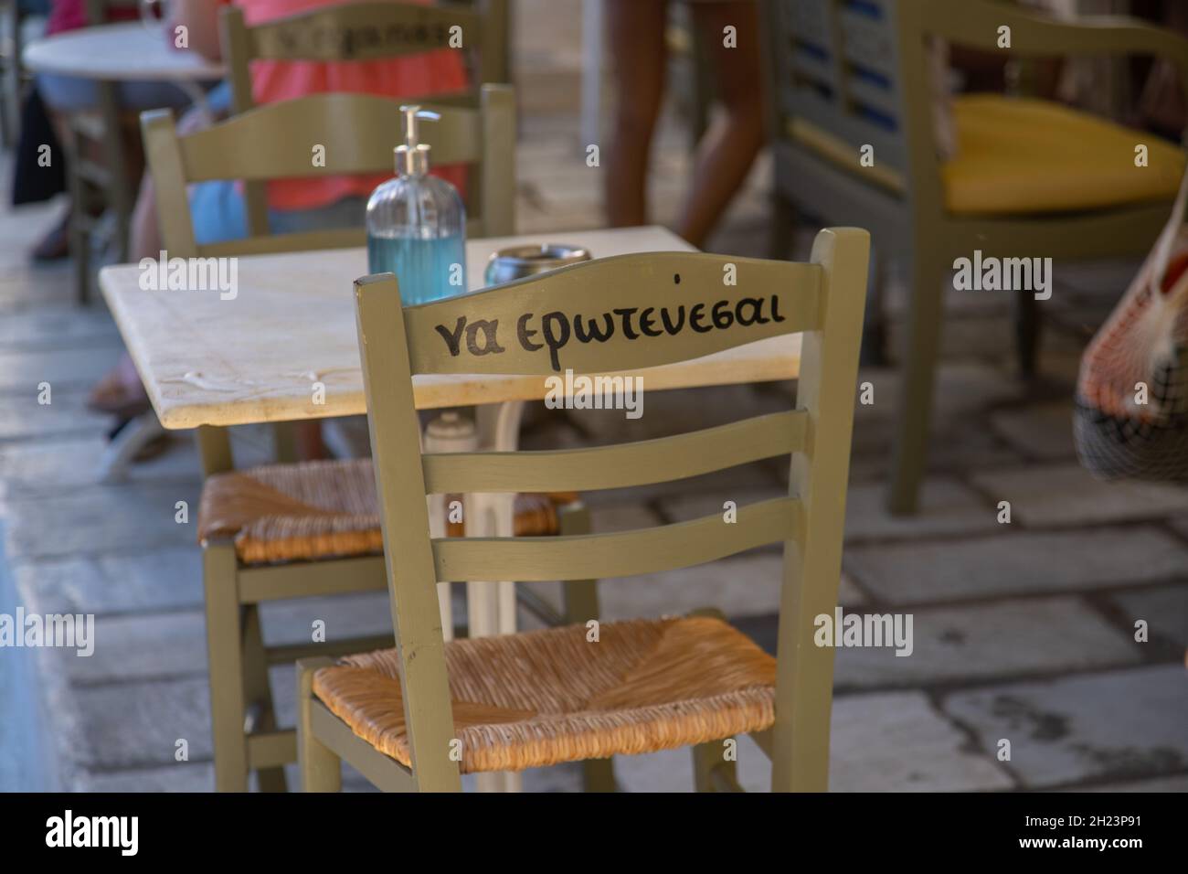 Schild auf der Rückseite eines Stuhls auf der Insel Tinos, Griechenland, mit der Aufschrift „verliebt euch“ Stockfoto
