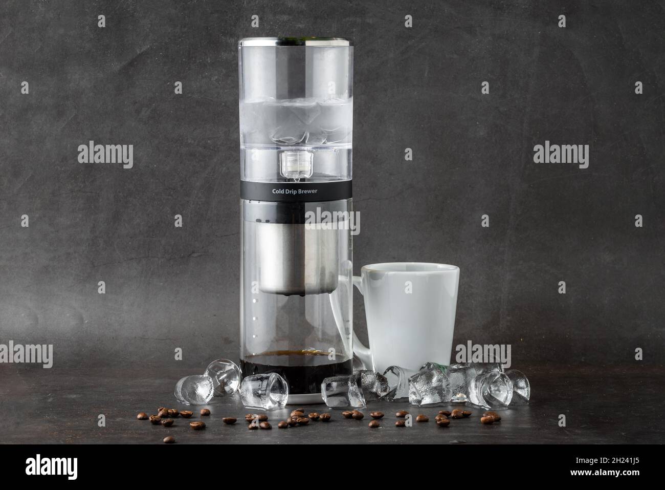 Moderne Cold Brew Drip Tower Kaffeemaschine auf dunklem Steinhintergrund Stockfoto