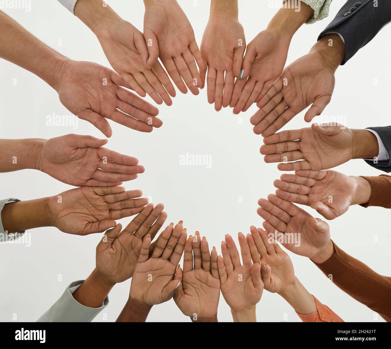 Ein vielfältiges Team von Menschen, das sich im Kreis zusammenschließt, um das Gemeinschaftskonzept zu veranschaulichen Stockfoto