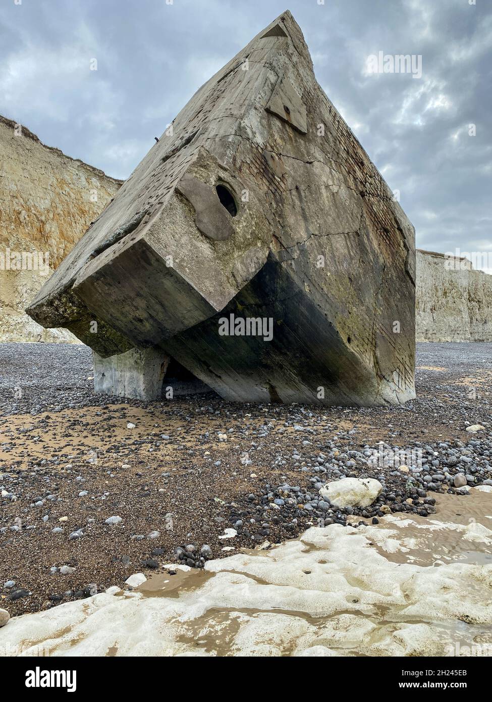 Ein riesiger Bunker des Atlantikwalls ist bei Sainte-Marguerite-sur-Meer von den Kreidefelsen gestürzt. Jetzt steht er aufrecht am Strand. Stockfoto