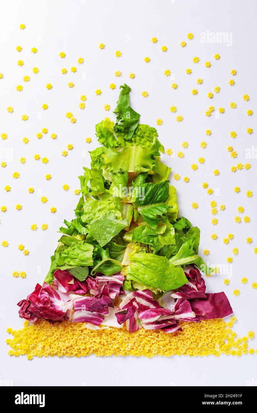 Weihnachtsbaum aus grünen Salatprodukten, Kohl, roher Pasta. Blick von oben Stockfoto