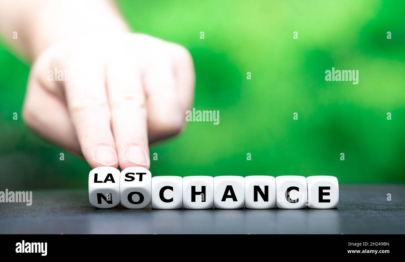 Hand dreht Würfel und ändert den Ausdruck „keine Chance“ in „letzte Chance“. Stockfoto