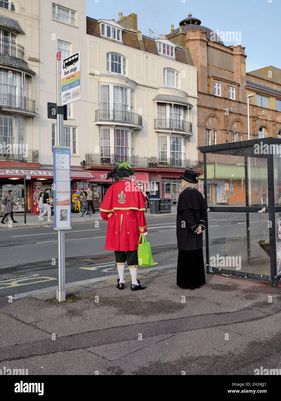 Everyday Hastings - das Warten auf den Bus an der Küste von Hastings kann eine lange Wartezeit sein Sussex England UK - ungewöhnliches seltsames, schrulliges Kleid aus der Zeit Stockfoto