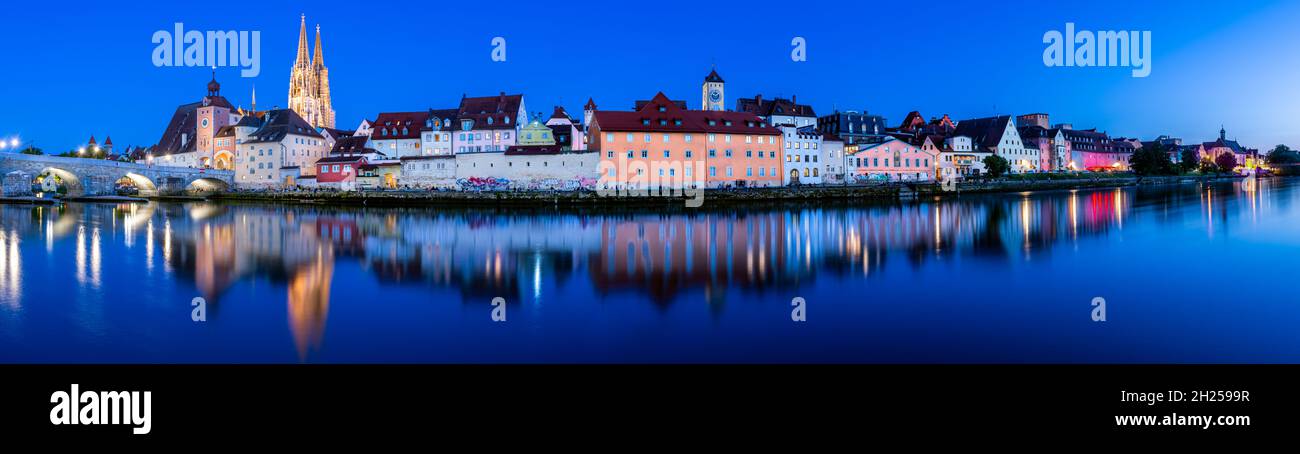 Altstadt Regensburg, beleuchtete Kathedrale und Steinbrücke zur blauen Stunde mit Spiegelung in der Donau Stockfoto