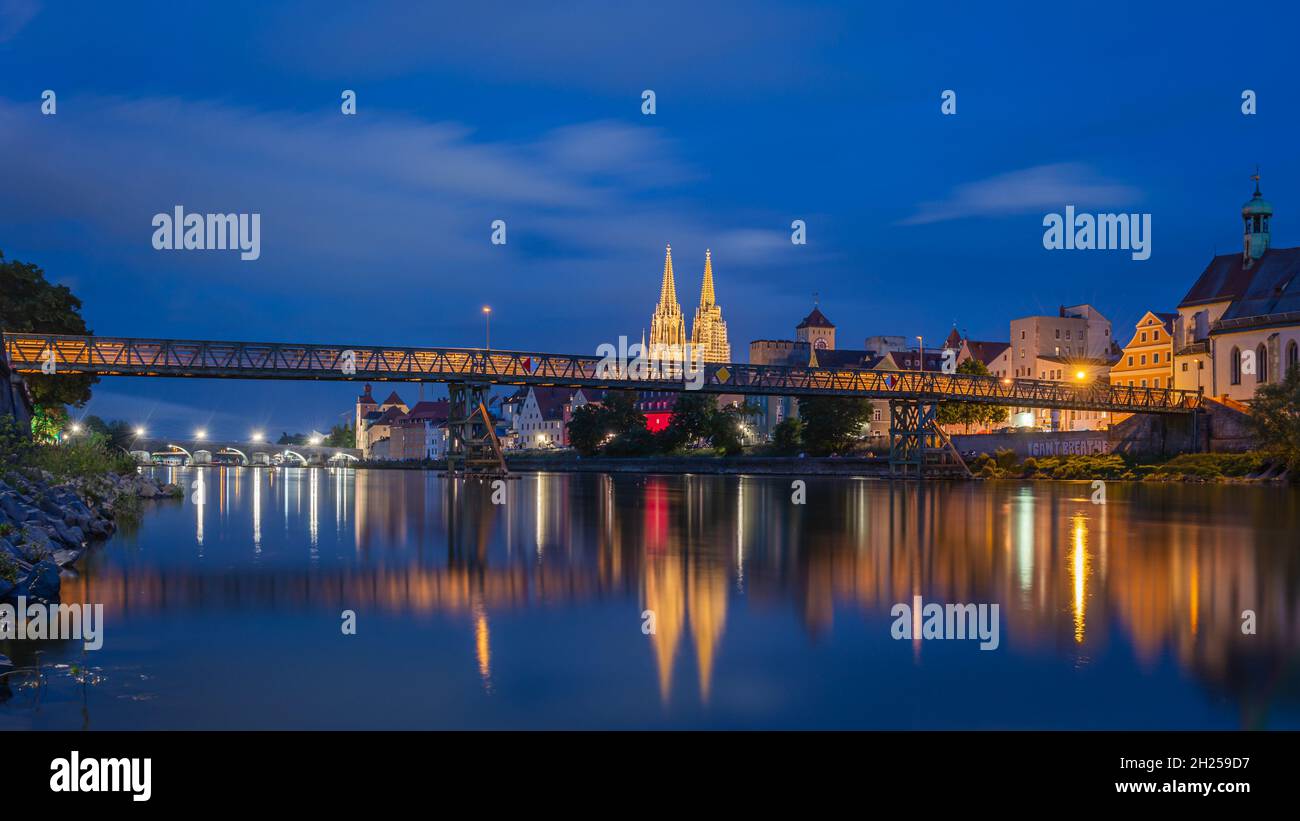 Altstadt Regensburg, beleuchtete Kathedrale und Steinbrücke zur blauen Stunde mit Spiegelung in der Donau Stockfoto