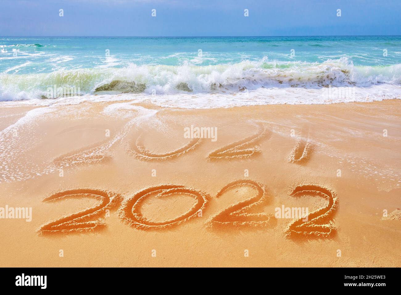 2022 geschrieben auf dem Sand eines Strandes, Wellen des Meeres, Reise Neujahr Grußkarte Stockfoto