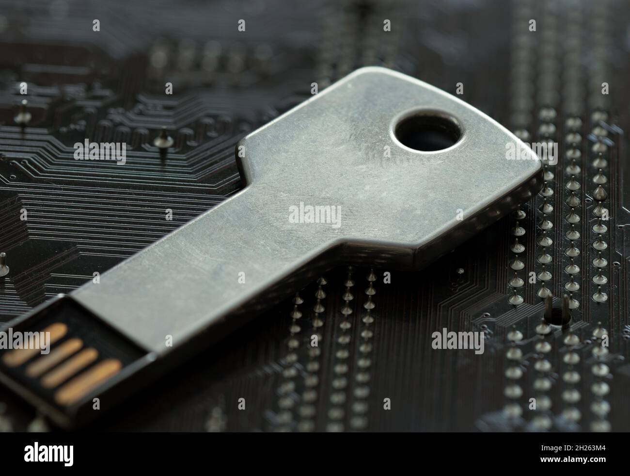 Schlüsselförmige Flash-Disk, die auf dem Mainboard steht. Konzept der Cyber-Sicherheit im Internet. Stockfoto