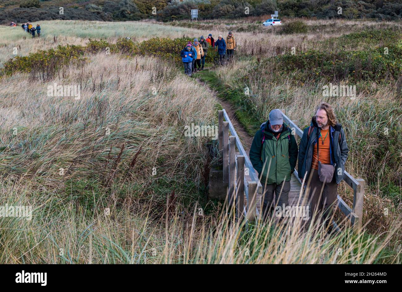 East Lothian, Schottland, Großbritannien, 20. Oktober 2021. COP26 Pilgerfahrt: Basisgruppen auf der schottischen Etappe eines Spaziergangs zur COP26. Die Teilnehmer sind der Ansicht, dass die COP26 nicht die wesentlichen Veränderungen herbeiführen wird, die zur Bekämpfung des Klimawandels erforderlich sind. Die Route befindet sich heute auf dem Küstenweg des John Muir Way. Im Bild: Umweltschützer Jonathan Baxter (rechts) führt den Weg Stockfoto