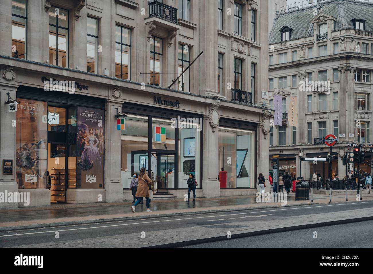 London, Großbritannien - 02. Oktober 2021: Nur wenige Menschen gehen an den offenen Geschäften von Microsoft und Onitsuka Tiger an einer ruhigen Regent Street vorbei, einem großen und typischen Bus Stockfoto