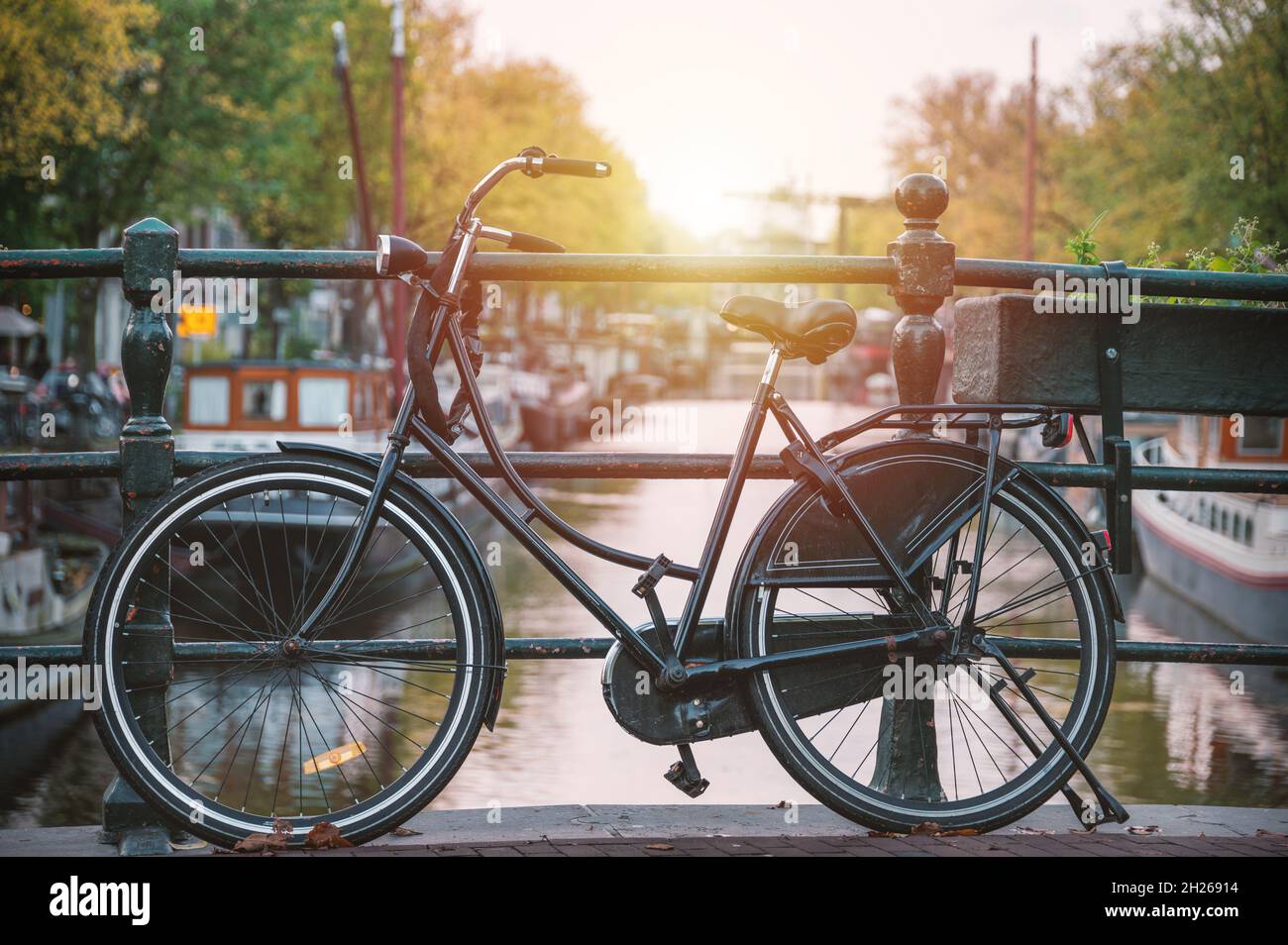 Radfahren auf einer Brücke in Amsterdam, Holland bei hellem Sonnenuntergang Stockfoto
