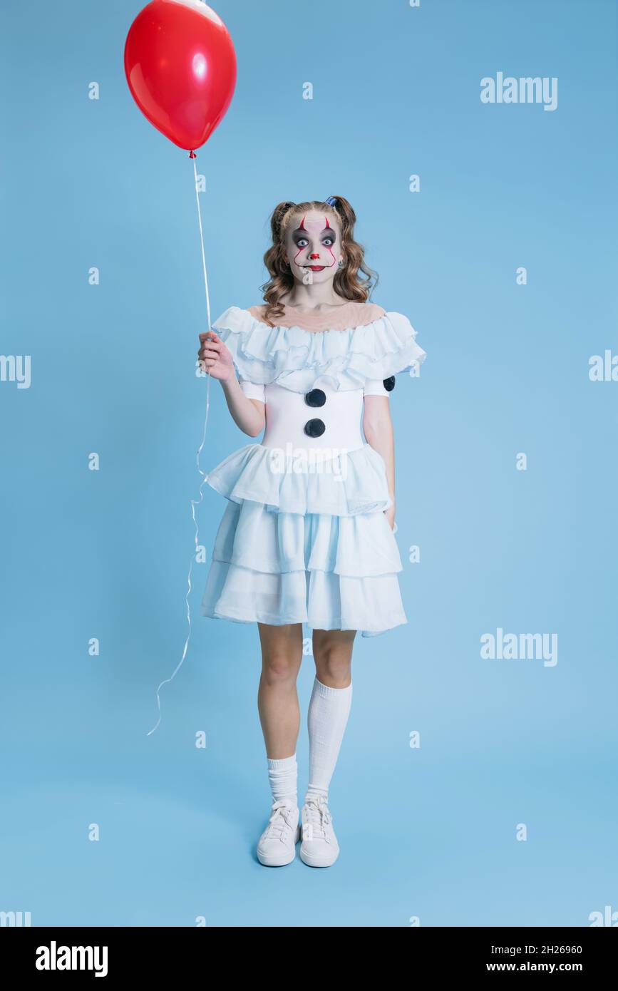 Konzeptuelles Bild von charmanten jungen Mädchen in Halloween Kostüm von  Filmcharakter mit gruseligen Gesichtsausdruck isoliert auf blauem  Hintergrund Stockfotografie - Alamy