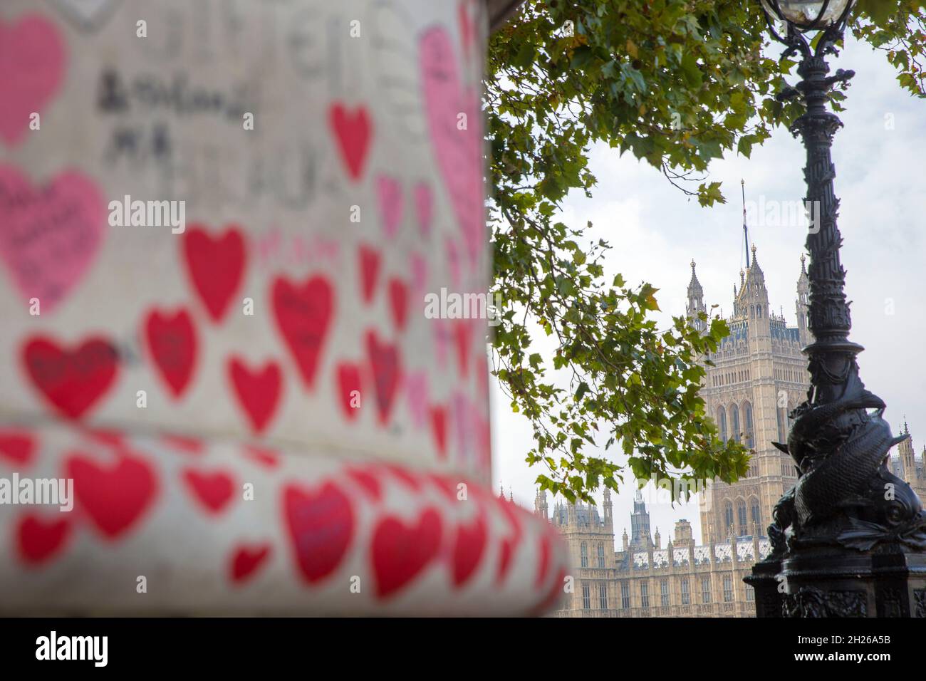 Der Palast von Westminster, die Houses of Parliament, ist hinter der National Covid Memorial Wall, im Zentrum von London, am Samstag, den 16. Oktober 2021, zu sehen. Stockfoto