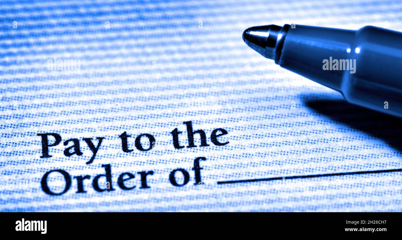 Rechnungen bezahlen und Geld mit einem Scheck und Stift Stockfoto