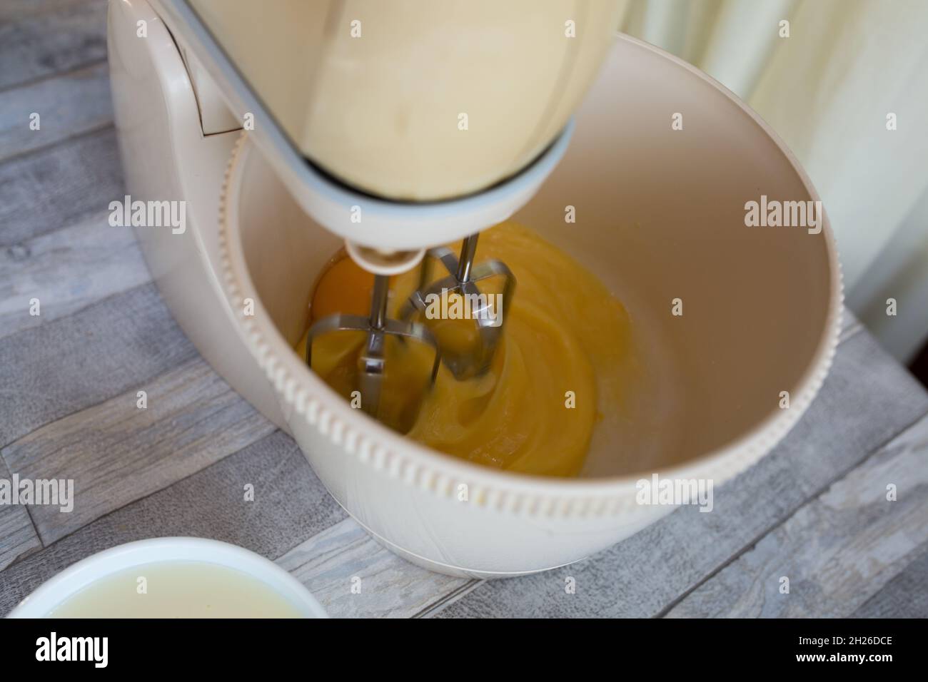 Der Prozess der Herstellung einer sauren Sahneschokolade Kuchen. Teigvorbereitung. Die Eier werden in einer Rührschüssel geschlagen. Schritt für Schritt Rezept für Schokoladenkuchen. Bak Stockfoto