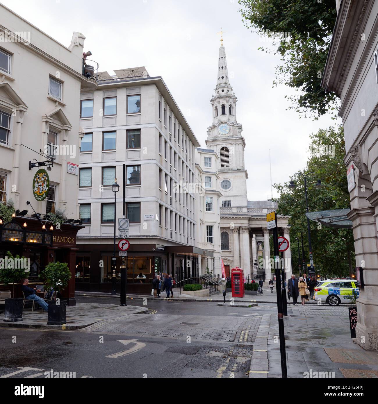 London, Greater London, England, Oktober 05 2021: Blick auf eine Red Phone Box mit St. Martin in der Fields Kirche hinter dem Trafalgar Square. Stockfoto