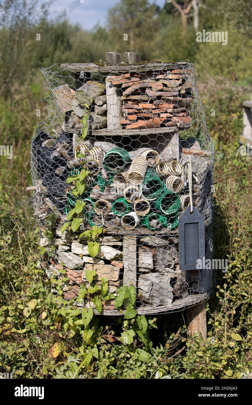 Das große Insekt- oder Insektenhotel ist ein von Menschen geschafftes Tierheim mit verschiedenen Abschnitten, um Nistmöglichkeiten oder Zufluchtsorte für viele Arten von Insekten Wildvögel und zu bieten Stockfoto