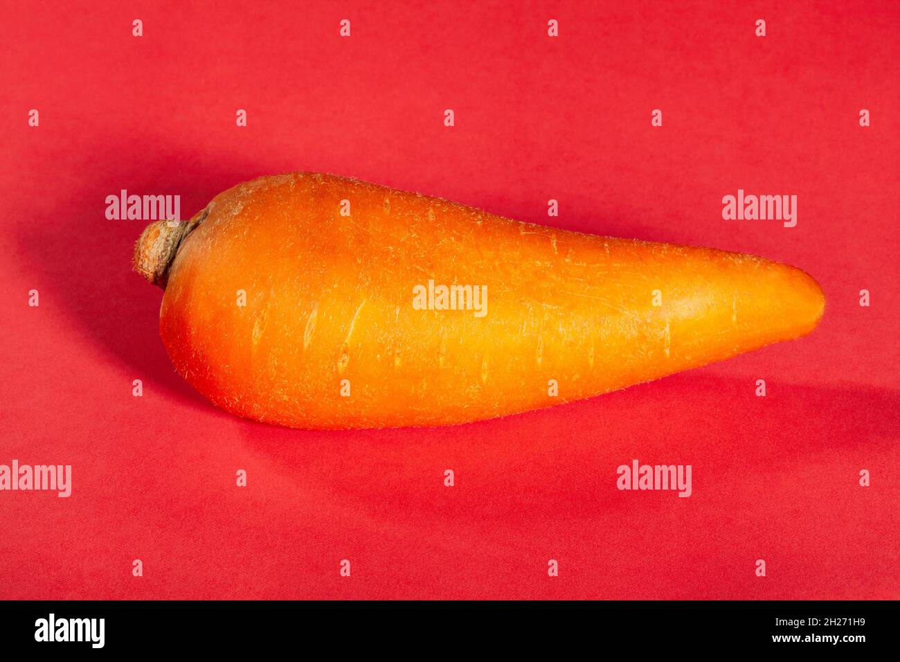 Eine Karotte auf rotem Hintergrund Stockfoto