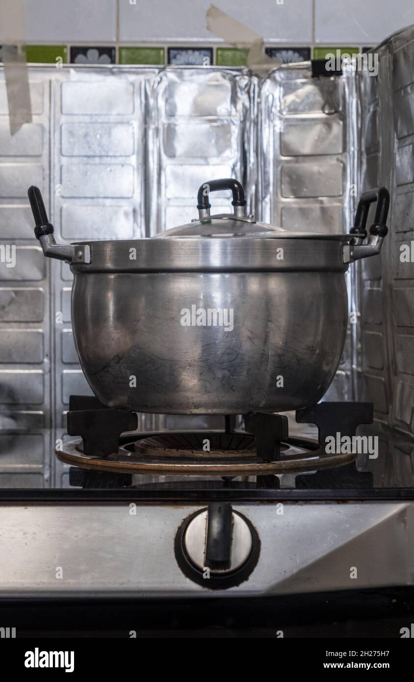 Der große Metalltopf auf dem Gasherd nach dem Kochen in der Küche des Stadthauses, Vorderansicht mit dem Kopierraum. Stockfoto