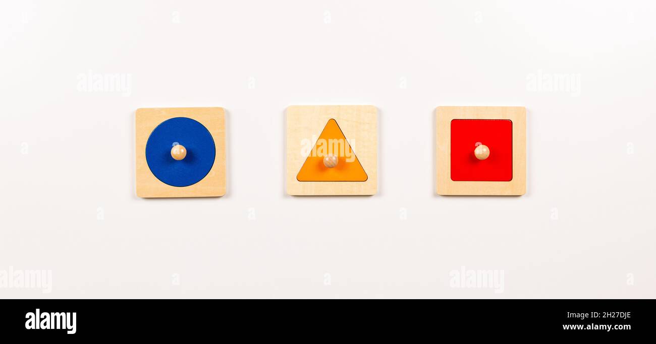 Bunte hölzerne Montessori sensorielles Material Lernen Lernspielzeug auf weißem Hintergrund. Geometrische Form Sortierbrett Spielzeug für Baby Kinder. Oben Stockfoto