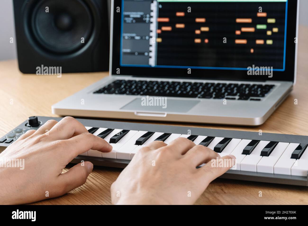 Mann spielt die Midi-Tastatur in einem Heimstudio. Stockfoto