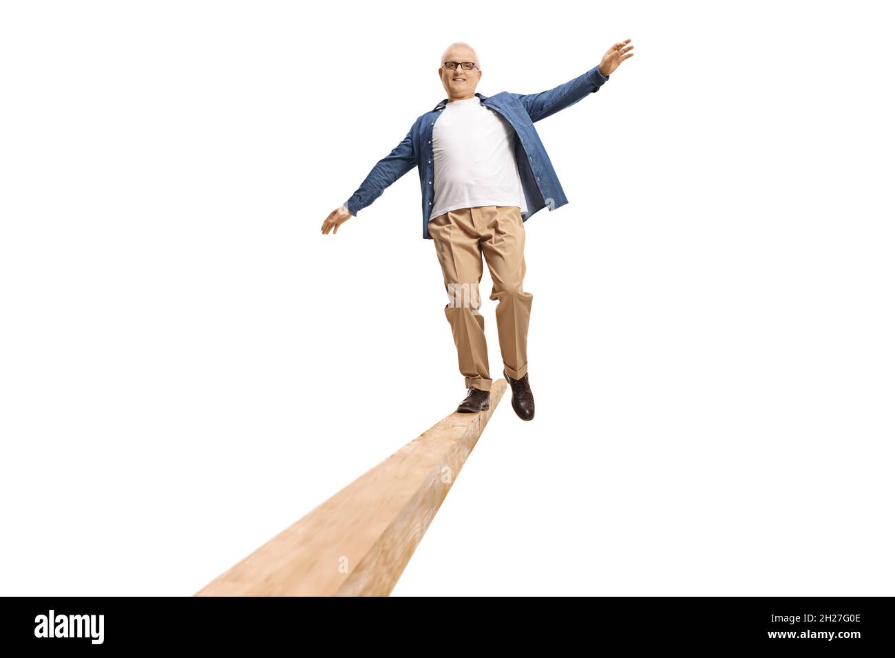 Ganzkörperportrait eines reifen Mannes, der auf einem Holzbalken auf weißem Hintergrund läuft Stockfoto