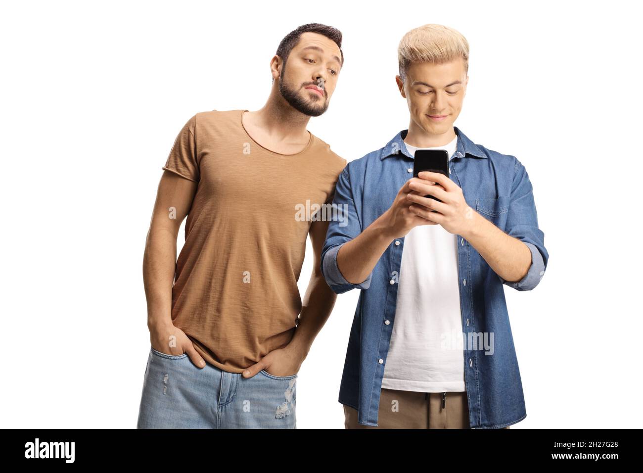 Junger Mann spioniert seinen Freund mit einem auf weißem Hintergrund isolierten Smartphone aus Stockfoto